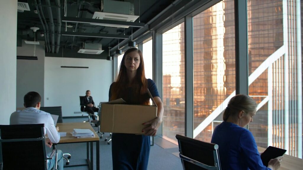 Employee leaving the office with a banker’s box after being terminated.